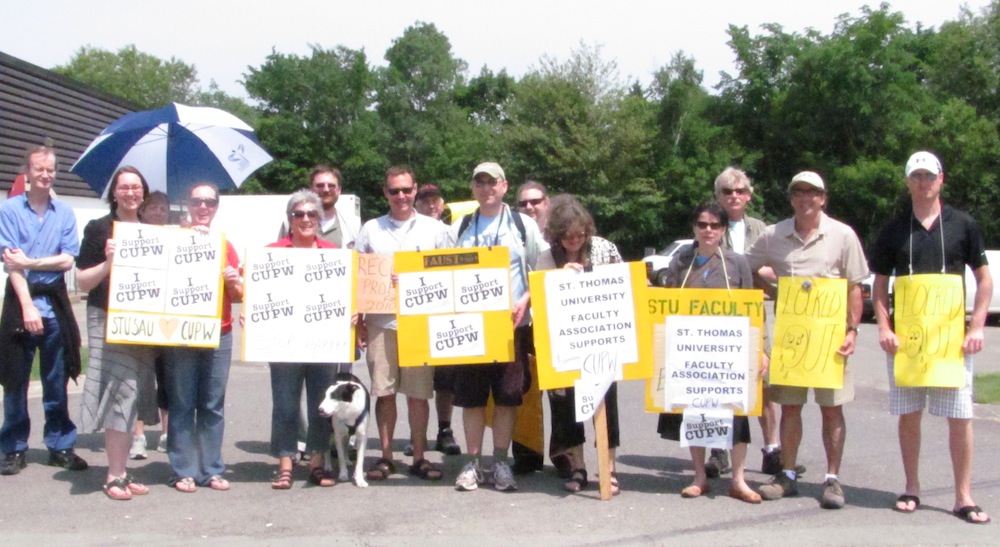 Members of the Faculty Association of the University of St. Thomas (FAUST) and the St. Thomas University Support and Administration Union (STUSAU) join the picket line with locked-out postal workers in front of the Waggoners Lane post office in Fredericton on June 17, 2011. Photo: Tracy Glynn. faust-cupw-3