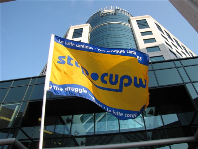A CUPW flag flies over postal worker lock out action at Canada Post in Ottawa on June 16, 2011. Photo: CUPW. manif lock-out cpc 008