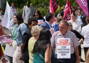A group of people rally in support of Pharmacare.