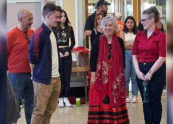 A group of people wearing red shawls.
