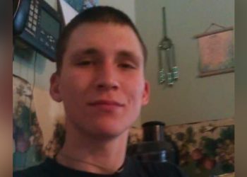 A young man with short dark hair is shown in a portrait photo.